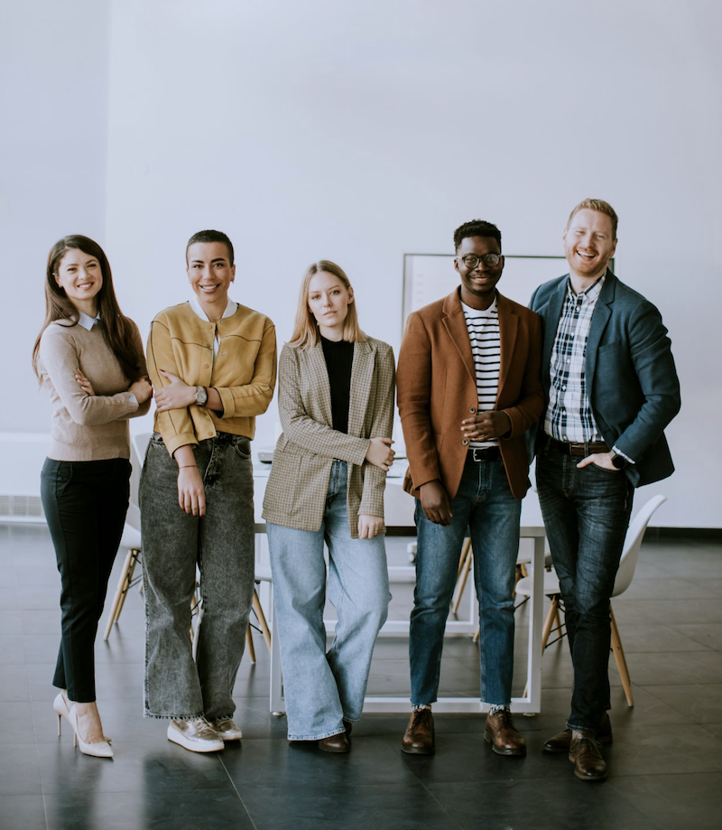 A course team consisting of five men and women standing up.