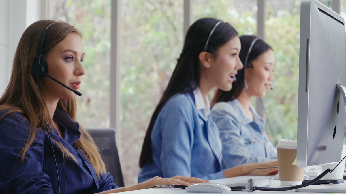 ding_scenario_based_learning_insurance Three women talking on the phone in a contact centre.